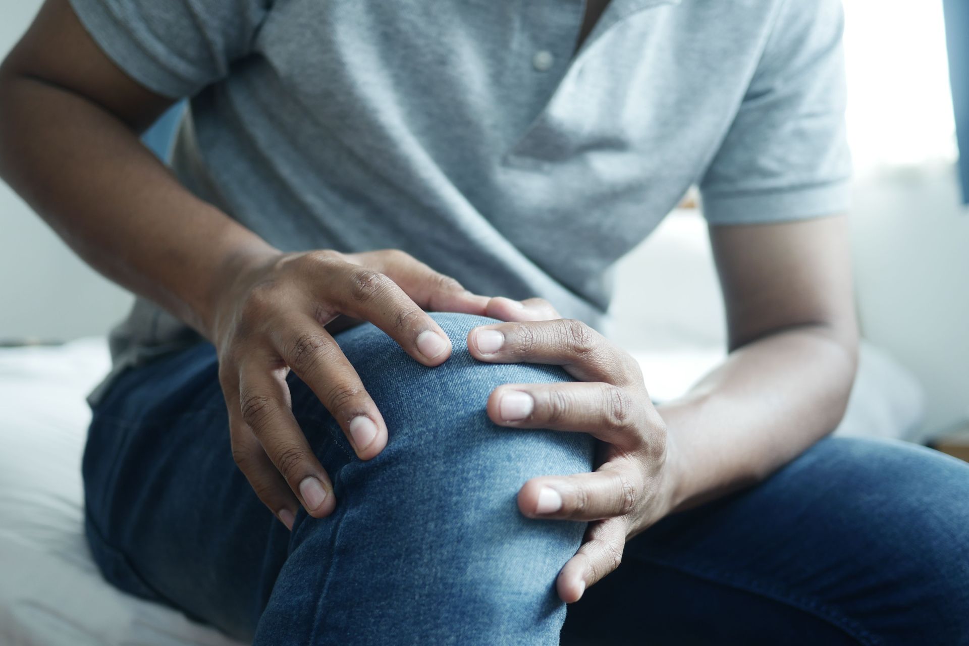 Man holding his swollen, painful knee before applying cold therapy for knee pain relief